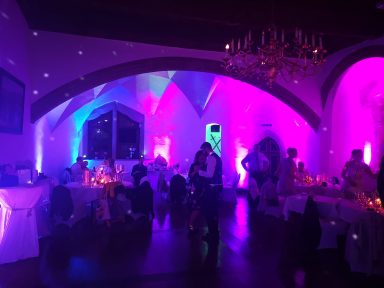 Festliche Veranstaltung mit buntem Licht, Tischen und Gästen in einem romantischen Ambiente. Photo by DJ Mirko Anders