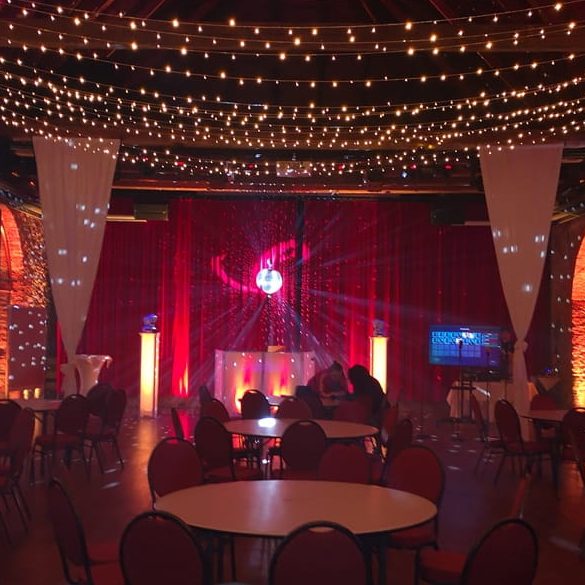 Festlich dekorierter Veranstaltungsraum mit Lichtern und runden Tischen im Kloster Nimbschen.