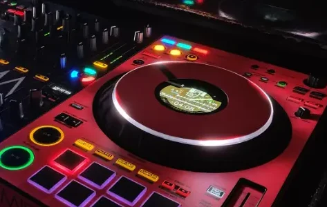 DJ-Pult mit bunten Lichtern, Plattenspieler und elektronischen Steuerungen.