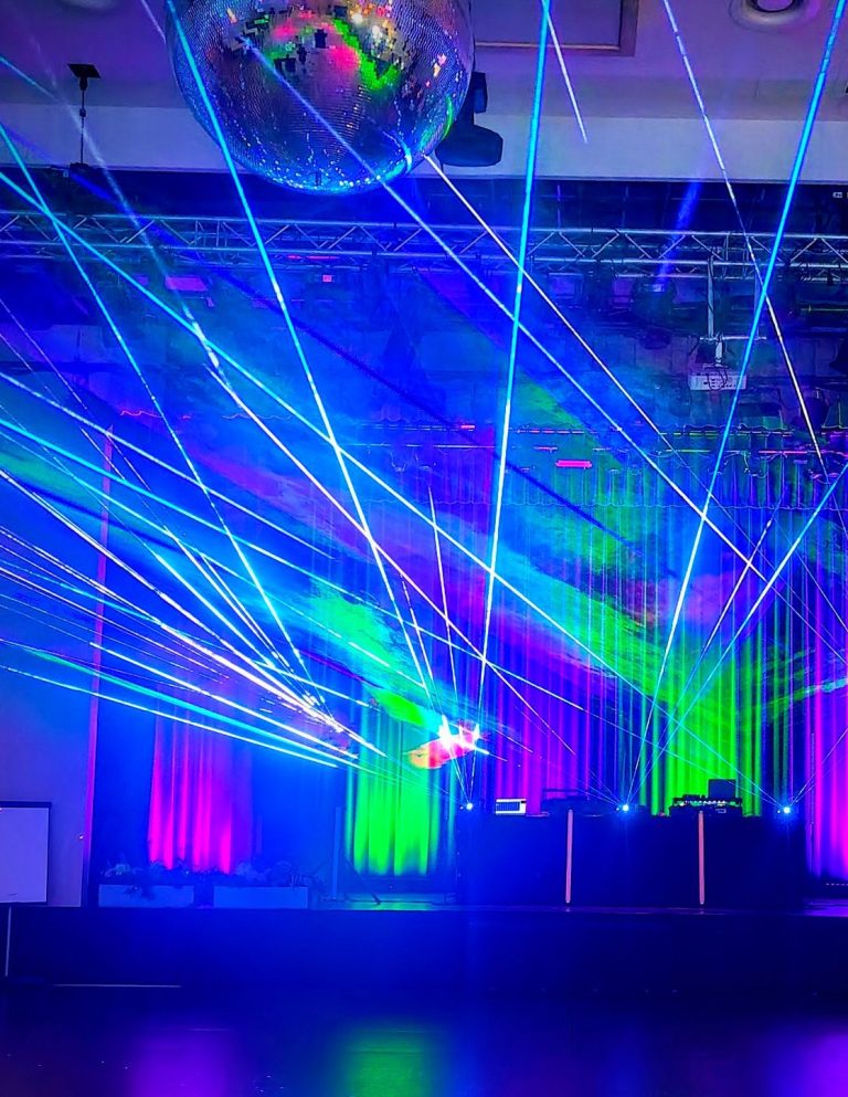 Bunte Laserstrahlen und Discokugel in einer festlichen Veranstaltungsumgebung.