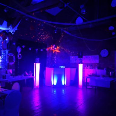 Dunkler Veranstaltungsraum mit bunten Lichtern und tanzendem Lichtspiel. Photo by DJ Mirko Anders
