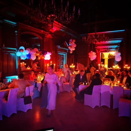 Elegante Feier in einem festlich beleuchteten Saal mit festlich dekorierten Tischen. Photo by DJ Mirko Anders