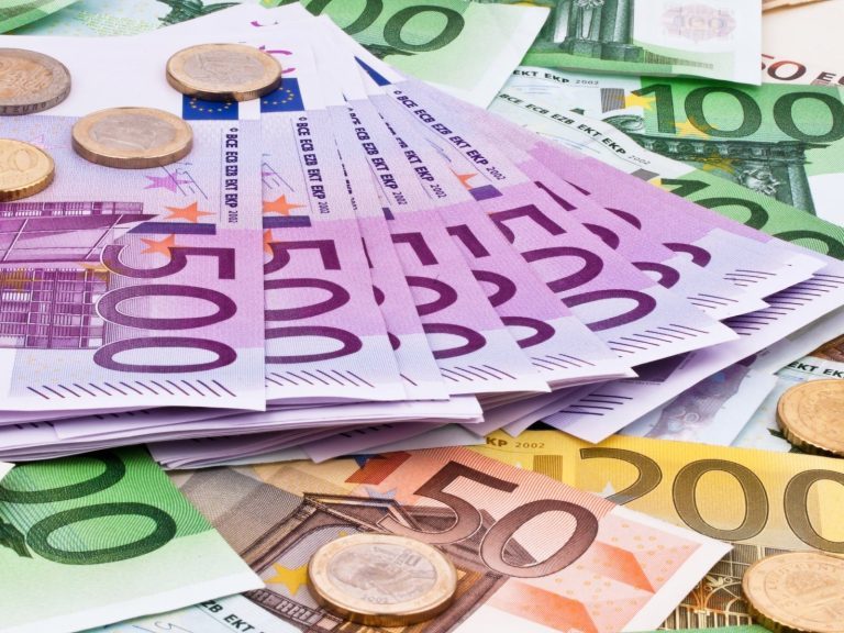 Bündel von Euro-Scheinen und Münzen in verschiedenen Denominationen.