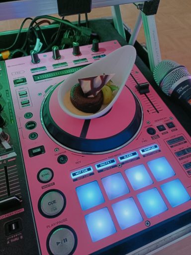 Ein DJ-Controller in Pink mit einem Dessert darauf. Photo by DJ Mirko Anders