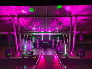 Bühne mit bunten Lichtern und Lautsprechern für eine Veranstaltung. Photo by DJ Mirko Anders