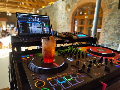 DJ-Equipment mit einem Getränk auf dem Pult in einem stilvollen Veranstaltungsort. Photo by DJ Mirko Anders