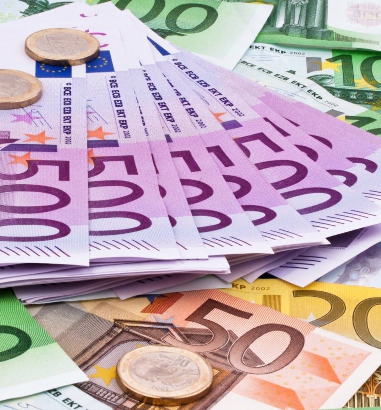 Bunt gemischte Euro-Banknoten und Münzen auf einem Tisch.