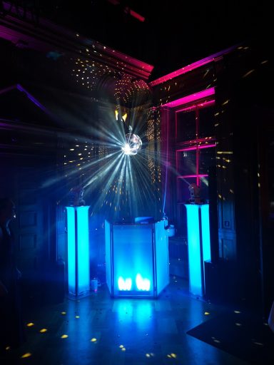 Disco-Kugel strahlt Licht von blauen Säulen in dunkler, festlicher Umgebung. Photo by DJ Mirko Anders