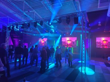 Bunte Lichter und Menschenmenge auf einer Tanzfläche in einem festlichen Veranstaltungsraum. Photo by DJ Mirko Anders