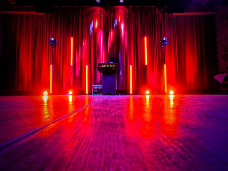 Beleuchtete Veranstaltung mit Menschen in einem modernen Raum und DJ-Setup.