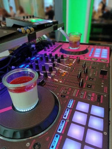 Ein DJ-Pult mit bunten Tasten und zwei Getränken in Gläsern. Photo by DJ Mirko Anders