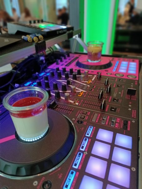 Ein DJ-Pult mit bunten Tasten und zwei Getränken in Gläsern. Photo by DJ Mirko Anders