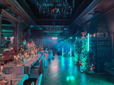 Elegante Veranstaltungsraum mit bunten Lichtern und festlich dekorierten Tischen. Photo by DJ Mirko Anders