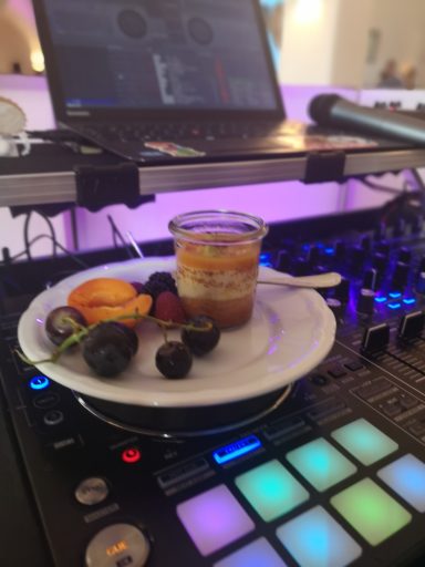 Dessert mit Fruchtstücken und einer Tasse auf einem DJ-Pult mit bunten Tasten. Photo by DJ Mirko Anders
