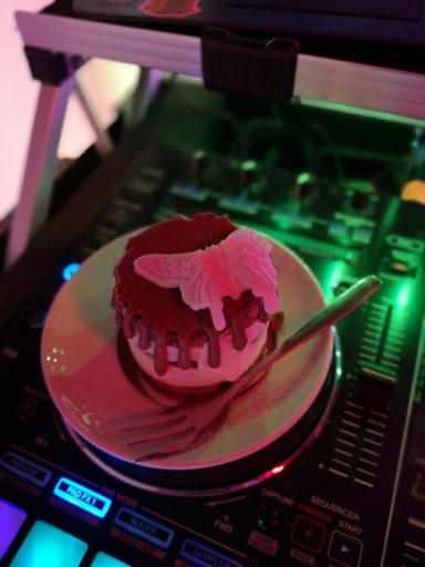 Ein Kirschkuchen mit Sahne auf einem Teller, neben einem DJ-Controller. Photo by DJ Mirko Anders