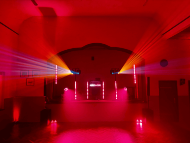 Roter Raum mit Lichtern und Scheinwerfern, die in verschiedenen Farben strahlen.