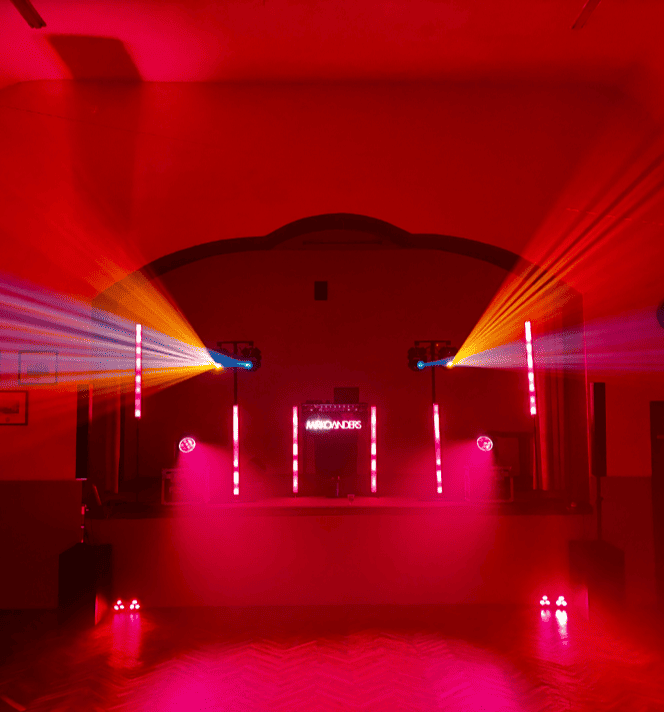 DJ Leipzig - Mirko Anders Bunte Lichtstrahlen in einem Raum mit roter Beleuchtung und futuristischem Ambiente.