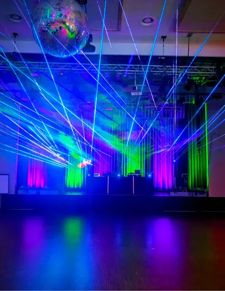Bunte Laserstrahlen und Discokugel in einer festlichen Veranstaltungsumgebung.