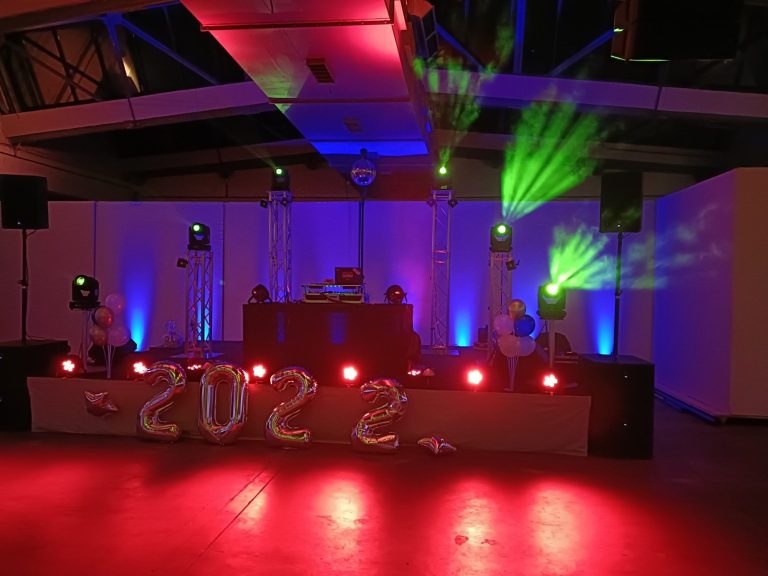 Party-Atmosphäre mit DJ und bunten Lichtern, Hintergrund beleuchtet in Blau und Grün.