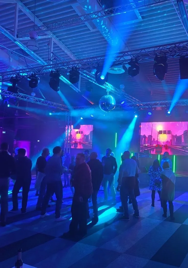 DJ-Pult mit bunten Lichtern, Plattenspieler und elektronischen Steuerungen.