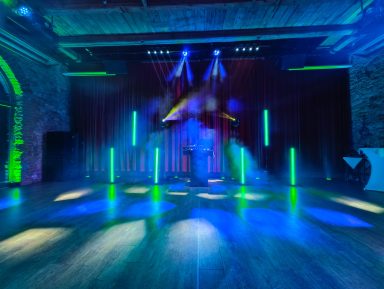 Bühne mit bunten Lichtern und Nebel in einem stilvollen Veranstaltungsraum. Photo by DJ Mirko Anders